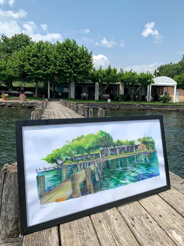 Quadro su molo di legno con sfondo alberato.
