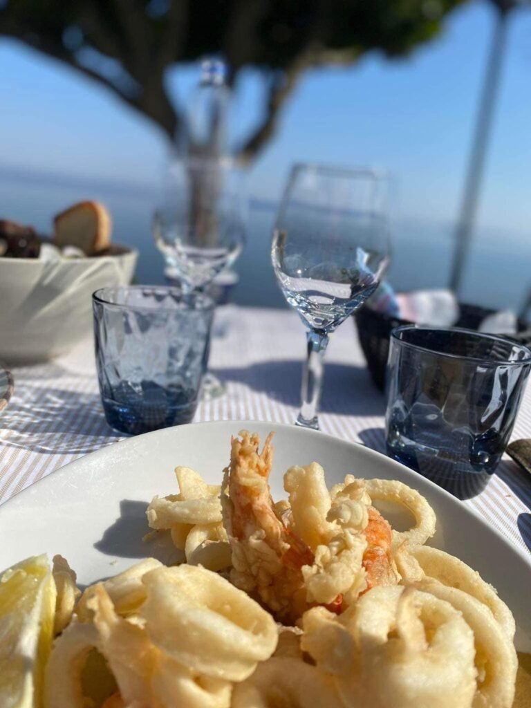 Piatto di fritto misto di mare su tavola apparecchiata.