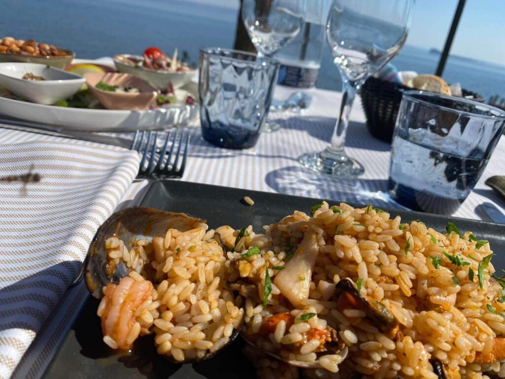 Piatto di riso ai frutti di mare su tavola apparecchiata.