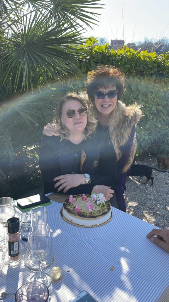 Due persone sorridenti con una torta su un tavolo.