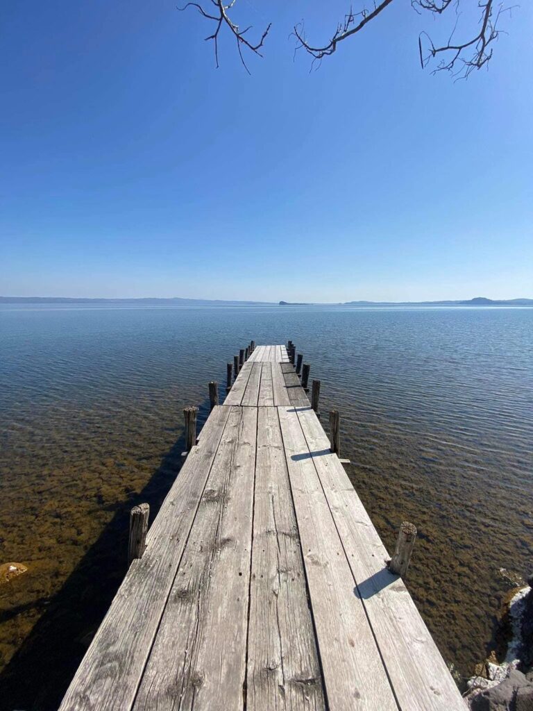 Ponte di legno su lago con cielo limpido.
