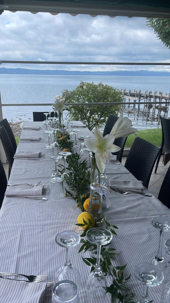 Tavola apparecchiata con fiori e limoni, vista lago.