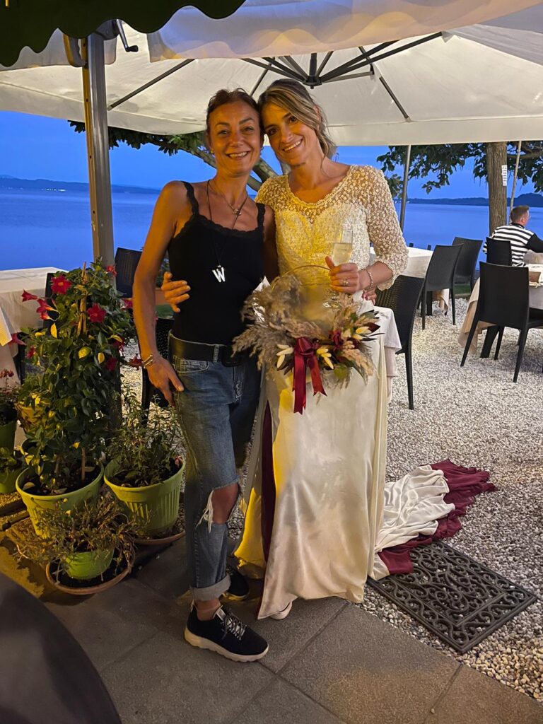 Due donne sorridenti, una in abito da sposa.