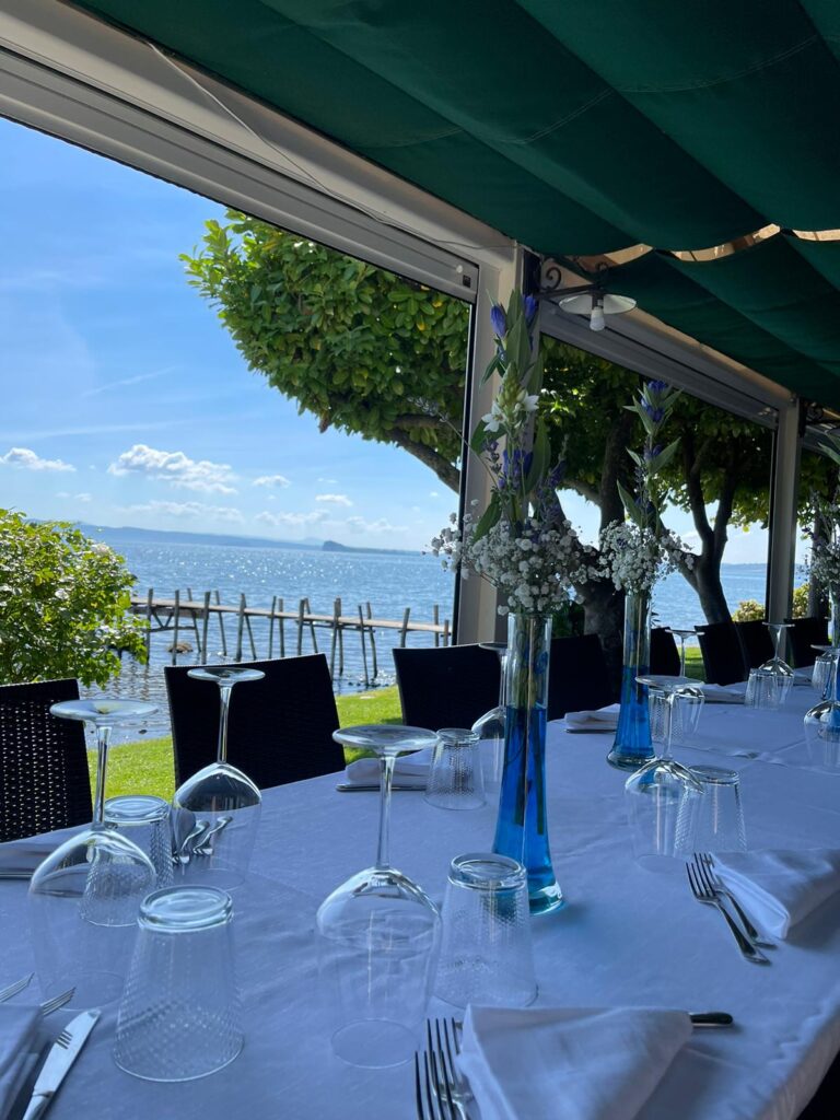 Tavola apparecchiata in ristorante con vista sul lago.