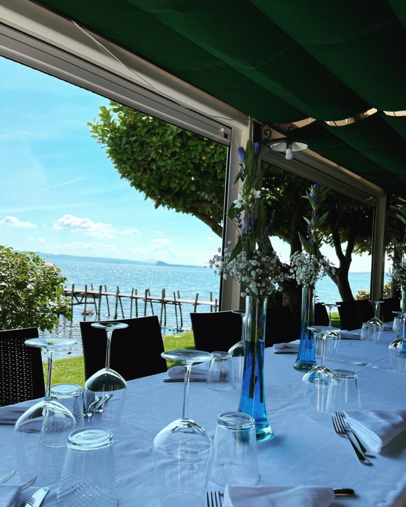 Tavolo apparecchiato con vista sul lago e pontile.
