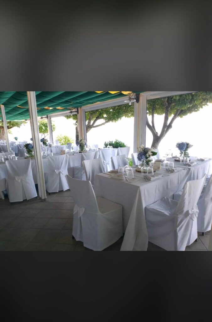Sala da pranzo elegante con tavoli apparecchiati e fiori.