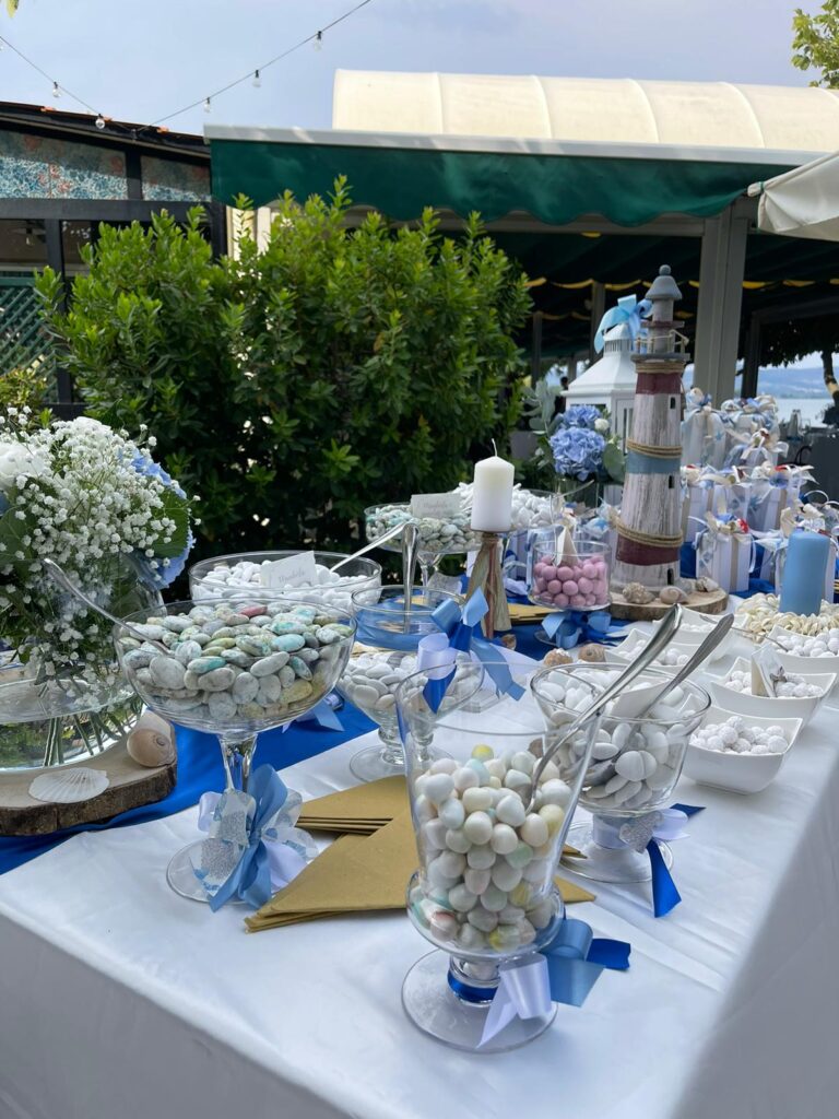 Tavolo con confetti colorati e decorazioni marine.