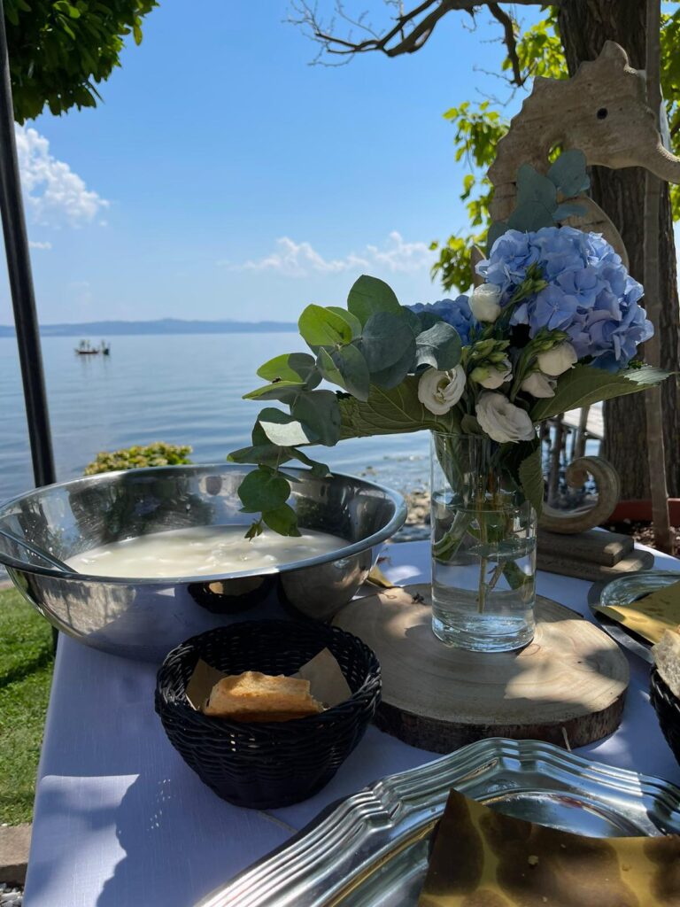 Tavolo con fiori, ciotola e pane, vista lago.
