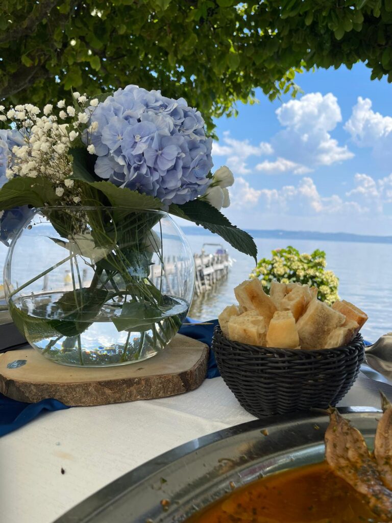 Vaso di fiori e pane su tavolo all'aperto.