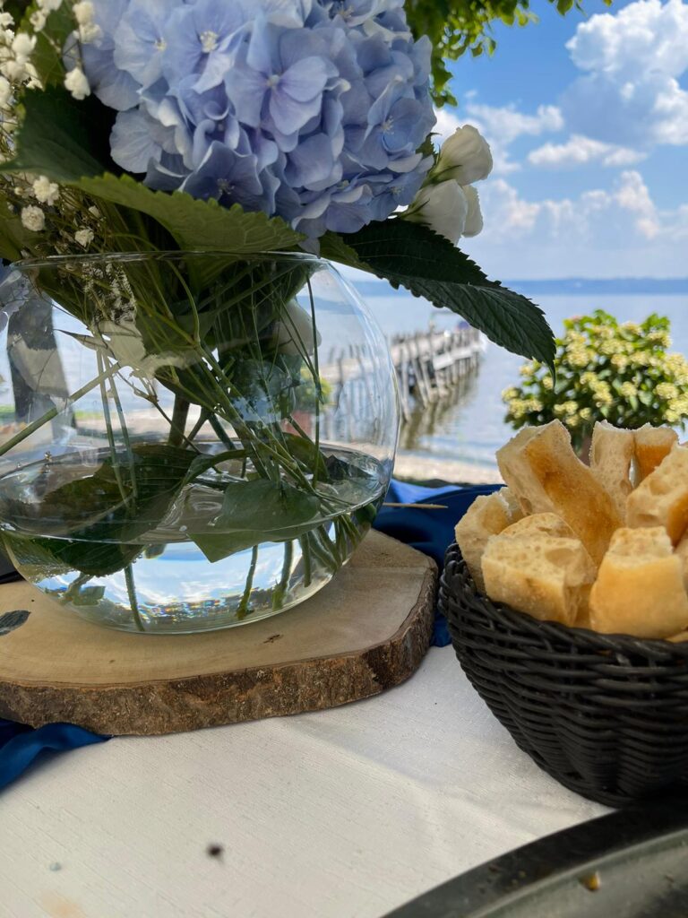 Vaso di fiori e pane su tavolo all'aperto.