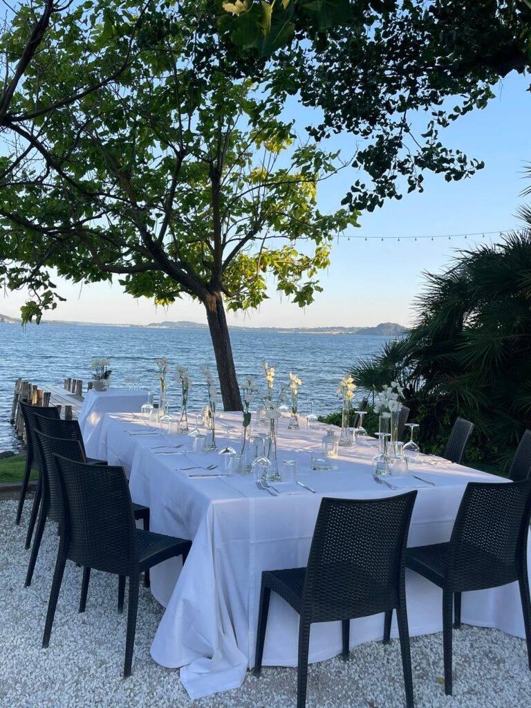 Tavolo apparecchiato all'aperto vicino al mare.