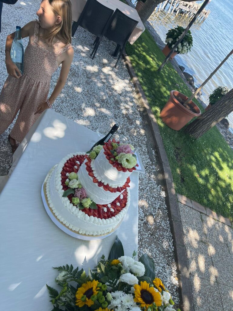 Torta a tre piani con fiori e frutta.