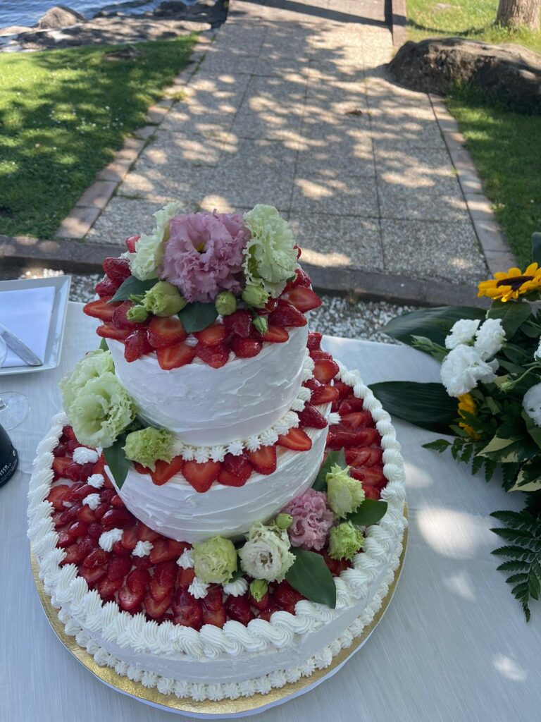 Torta a tre piani con fragole e fiori.