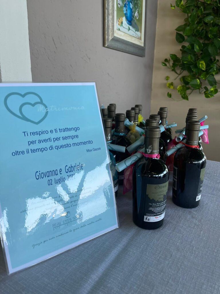 Bottiglie di vino e cartello con dedica matrimoniale.