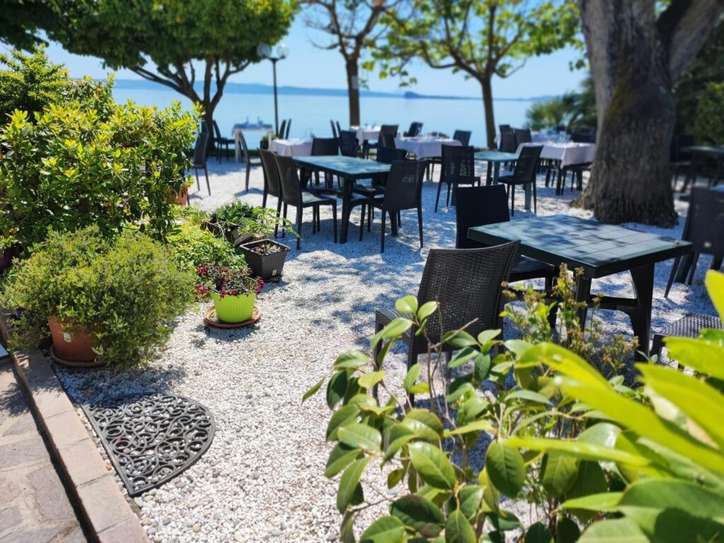 Tavoli all'aperto in giardino con vista sul mare.