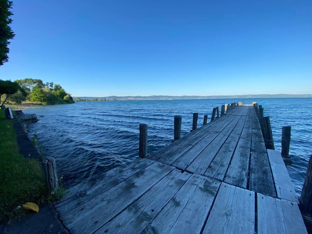 Pontile in legno su un lago con cielo sereno.