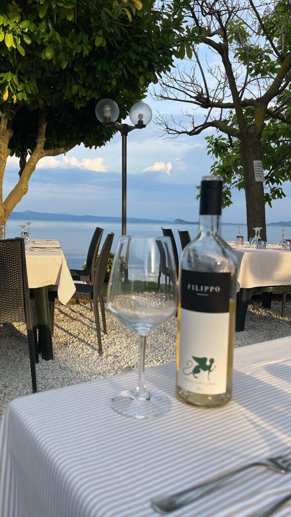 Bottiglia di vino su tavolo all'aperto, vista lago.