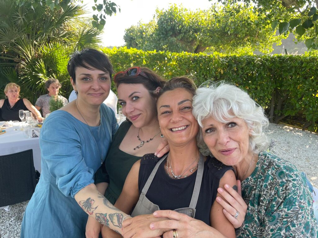 Quattro persone sorridenti in un giardino.