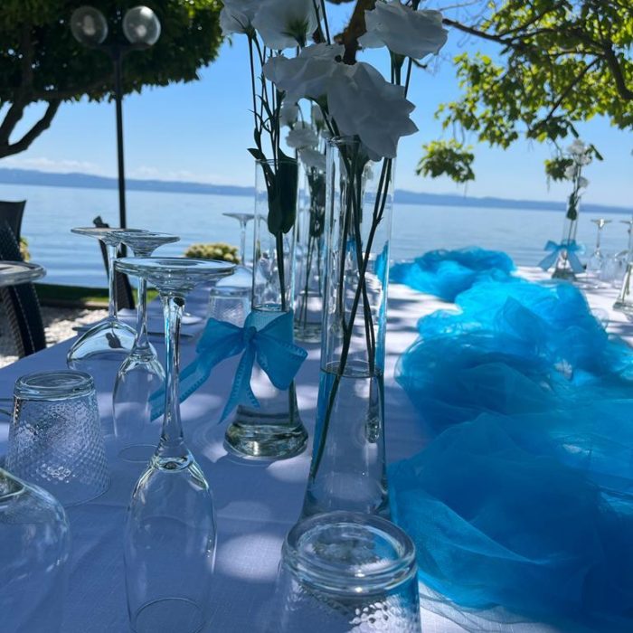 Tavola apparecchiata con fiori bianchi e decorazioni blu.