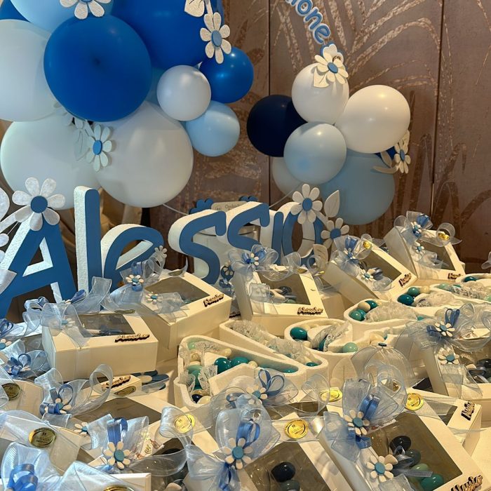Decorazioni e bomboniere per comunione con palloncini blu.