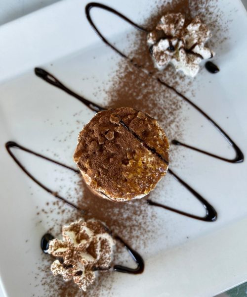 Schokoladendessert mit Schlagsahne und Dekorationen.