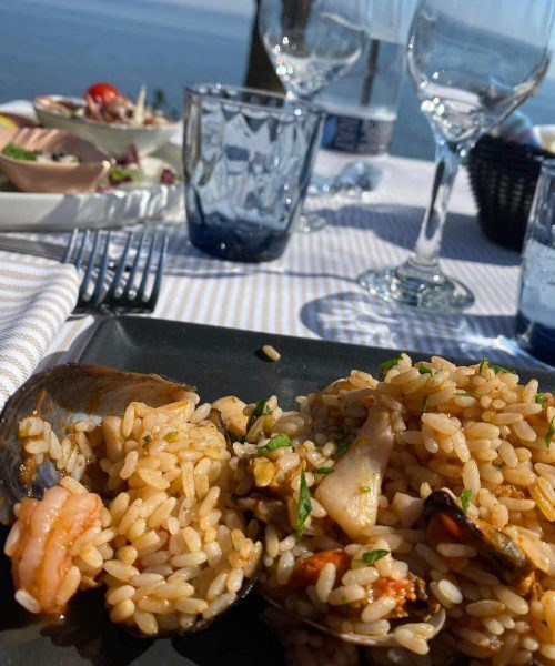 Reisgericht mit Meeresfrüchten auf einem Tisch im Freien.
